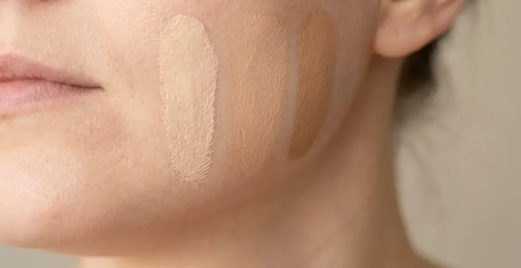 Comparación de tres tonos de base de maquillaje aplicados en la línea de la mandíbula bajo luz natural Comparación de tres tonos de base de maquillaje aplicados en la línea de la mandíbula bajo luz natural